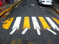 an empty parking lot with yellow and white painted lines on the ground next to parked cars