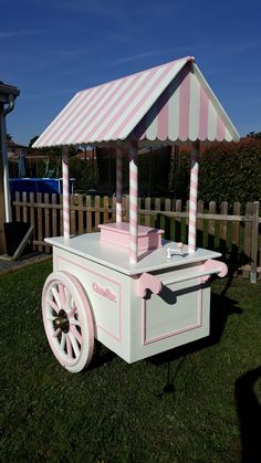 a pink and white cart sitting in the grass