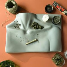 a tray with various items on it including yarn, candles and marijuanas next to them