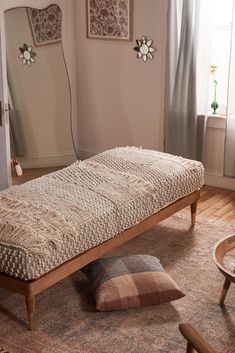 a wooden bench sitting on top of a rug in a living room next to a window