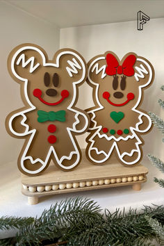 two gingerbread cutouts are sitting on a shelf