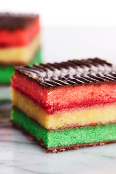 three different colored desserts sitting on top of a marble countertop next to each other