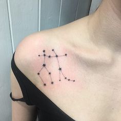 a woman's shoulder with a small star tattoo on it