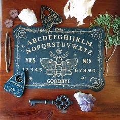 an assortment of old keys and other items on a wooden table with a sign that says, abcdefeghium noorstufwyy yes goodbye