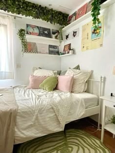 a white bed sitting in a bedroom next to a green and white rug on top of a hard wood floor