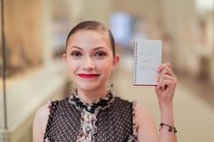 a woman holding up a notepad in front of her face