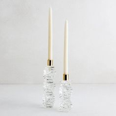 two white candles sitting next to each other