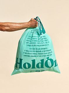 a man is holding a bag that says hold on to the back of his arm