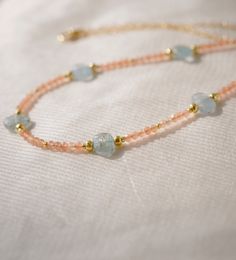 Feel the captivating charm of Kyanite and Sunstone in this hand-beaded necklace! This dainty design, available in 14k gold filled or sterling silver, exquisitely combines the warmth of Sunstone with the icy-blue allure of aqua Kyanite. Kyanite, known for promoting self expression and encouraging spiritual wisdom, pairs perfectly with Sunstone—the gem for joy and confidence. This is not just a necklace, but a celebration of your journey and growth!MODELED LENGTH: 16 Inches Delicate Crystal Necklaces With Tiny Beads For Gift, Dainty 14k Gold Filled Necklaces With Gemstone Beads, Dainty 14k Gold Filled Gemstone Beads Necklace, Gold Rondelle Crystal Necklace With Gemstone, Delicate Gemstone Beaded Necklaces, Gold Dainty Rondelle Beaded Necklaces, Everyday Gold Beaded Necklace With Natural Stones, Gold Gemstone Beaded Necklace In 14k Gold Filled, Handmade Dainty 14k Gold-filled Crystal Necklace