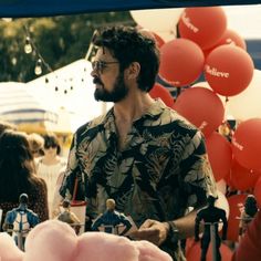 a man standing in front of a bunch of balloons