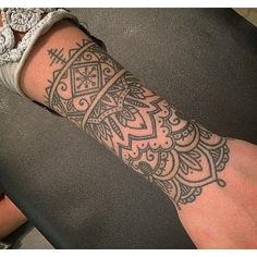 a person with a tattoo on their arm is sitting down and looking at the camera