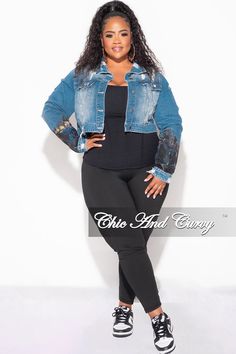 a woman in black pants and denim jacket posing for the camera with her hands on her hips