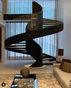 a living room filled with furniture and a spiral staircase next to a glass coffee table