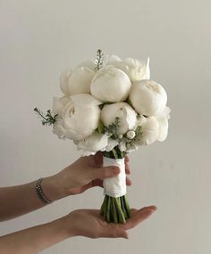 a person holding a bouquet of white flowers