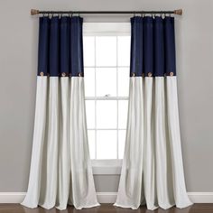 a window with blue and white curtains hanging on the wall next to a wooden floor