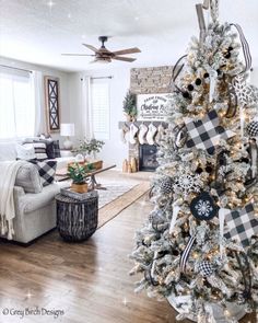 a decorated christmas tree in the middle of a living room with white and black decorations