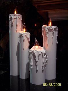 three white candles that are sitting on a table