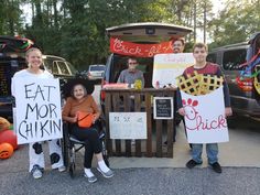 some people are holding signs and posing for a picture in front of their cars with pumpkins