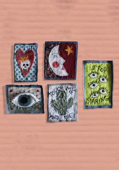 four square patches with eye designs on them, one has a skull and the other has an eye