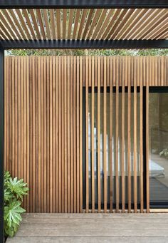 an outdoor area with wooden slats and plants