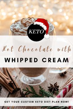 keto hot chocolate with whipped cream in a glass mug surrounded by cinnamon sticks and christmas decorations