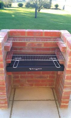 an oven built into the side of a brick wall in front of a green field