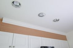 a stove top oven sitting inside of a kitchen next to white cupboards and cabinets