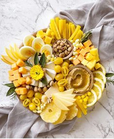 a platter filled with assorted fruits and veggies on top of a gray napkin