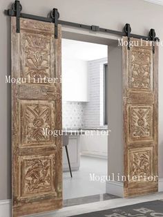 an ornate wooden door is open to reveal a bathroom with white walls and flooring