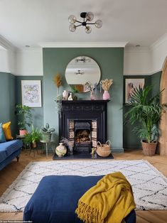 a living room filled with furniture and a fire place next to a blue couch in front of a mirror