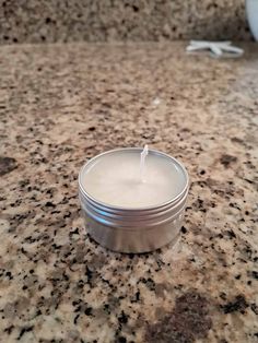 a white candle sitting on top of a counter