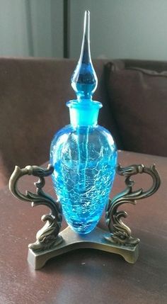 a blue glass vase sitting on top of a wooden table