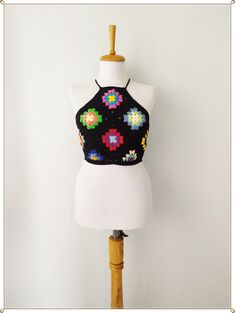 a mannequin wearing a black crop top with colorful flowers on the front and back