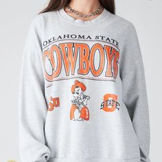 Vintage Ncaa Oklahoma State Cowboys Logo Sweatshirt, Oklahoma State Cowboys Shirt, Oklahoma State University, Unisex Shirt, Vintage Shirt Our Classic T-Shirt Serves As The Perfect Short-Sleeved Shirt For Your Unique, Funny, Or Personalized Designs. Brand: Gildan Heavy Weight Fabric Classic Unisex Makes This An Easy Fit Size Up If You Want Something Roomier Our Shirts Materials: 100% Cotton ** Note: - Double Check Your Address Before Ordering. - If You Want To Return The Goods, You Are The One To Gray Crew Neck Top For Campus, College Style Game Day Sweatshirt With Graphic Print, College Style Sweatshirt With Graphic Print For Game Day, College Style Graphic Sweatshirt For Game Day, Fall Campus Top With Logo Print, Retro Oversized Tops For Game Day, Oversized Retro Top For Game Day, Collegiate Tops With Letter Print For Campus, Collegiate Letter Print Tops For Campus