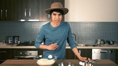 a man standing in front of a kitchen counter with utensils and bowls on it