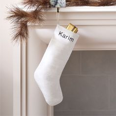 a christmas stocking hanging from a mantel with the word karmi written on it