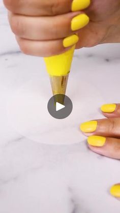 someone is painting their nails with yellow acrylic