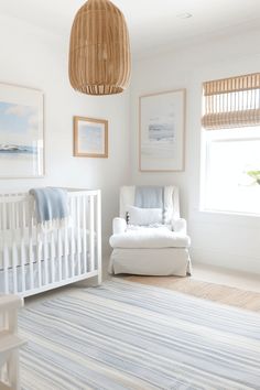 a baby's room with a crib, chair and pictures on the wall