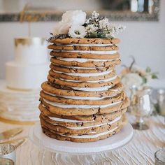 a wedding cake made out of cookies and frosting with flowers on the top tier