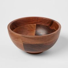 a wooden bowl sitting on top of a white table