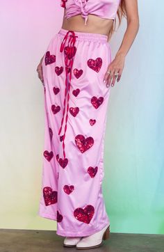 Introducing our Cupid's Crossfire Satin lounge pants- our venture into comfy everyday clothes that bring some sparkle into your world! These wide leg silky pants are hand beaded with delicate red hearts and have a comfy elastic waistband with a red satin tie. The inseam is roughly 28". Perfect for any occasion - whether you're at a festival, on a night out with your friends or just at home looking fabulous. In stock and ready to ship- Limited Stock! Silky Pants, Headpiece Accessories, Everyday Clothes, Red Hearts, Red Satin, Limited Stock, Lounge Pants, Hand Beading, Skirt Pants