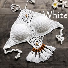 a white crocheted hat with tassels and beads on top of it