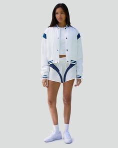 Designed in a cropped silhouette, this bomber jacket is modeled after classic varsity styles. It's made from Taslon, a breathable and resistant tech fabric, with contrast inserts at the shoulders, striped ribbed trims, snaps down the front and logo embroidery on the reverse side of the collar. Colorblock detail at shoulders Striped rib trim at neck, sleeve opening, bottom opening Snap front closure Logo embroidery at back neck Taslon 100% Polyester The Cropped Varsity Bomber Jacket is styled wit Luxury Cotton Varsity Jacket In Sporty Style, Luxury Casual Varsity Jacket With Ribbed Cuffs, Cheap Spring Varsity Jacket With Ribbed Cuffs, Cheap Hooded Varsity Jacket With Ribbed Cuffs, Luxury Varsity Jacket With Ribbed Cuffs For Sports, Cheap Varsity Jacket With Ribbed Cuffs For Sports, Windbreaker Shorts, Race Outfit, Vintage Windbreaker Jacket