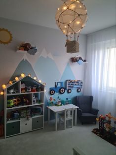 a child's room decorated in blue and white with mountains painted on the wall