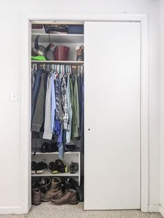 an open closet with clothes and shoes on the floor in front of white walls,