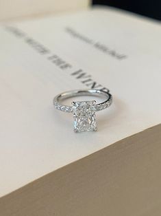 a diamond ring sitting on top of a book