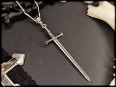 Simple Occult Sword Necklace. You can choose between 2 colors. You can also find different matching earrings in my shop: https://www.etsy.com/de/listing/1307602320/valkyrie-silber-schwert-ohrringe-okkulte?click_key=762339c72a17285ca46f7c0559e53ac8f2bfe7b9%3A1307602320&click_sum=3e8a2b71&ref=shop_home_active_5&pro=1 https://www.etsy.com/de/listing/969953439/warrior-silber-schwert-ohrringe-in-3? click_key=b7f62c2be0da42196ebb42a3fec11063144a259a%3A969953439&click_sum=013cd762&ref=shop_home_active_ Matching Necklaces Aesthetic, Gothic Jewellery, Witch Necklace, Celtic Necklace, Edgy Jewelry, Clothing Aesthetic, Necklace Gothic, Witch Jewelry, Gothic Necklace