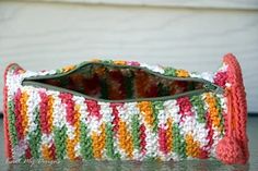 a crocheted purse sitting on top of a table next to a white door