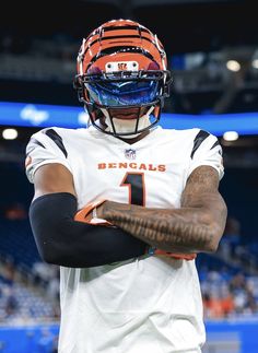 a close up of a person wearing a football uniform and holding his arms crossed in front of him