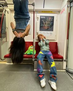 two people hanging upside down on a train